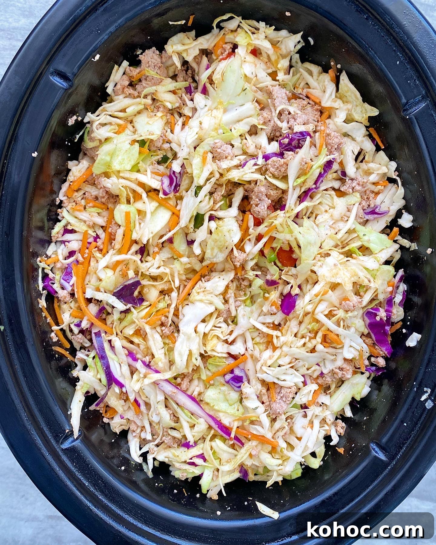 Spicy Slow-Cooker Turkey Slaw Recipe for Quick Weeknight Meals 4 overhead shot of uncooked spicy turkey slaw in a black slow cooker