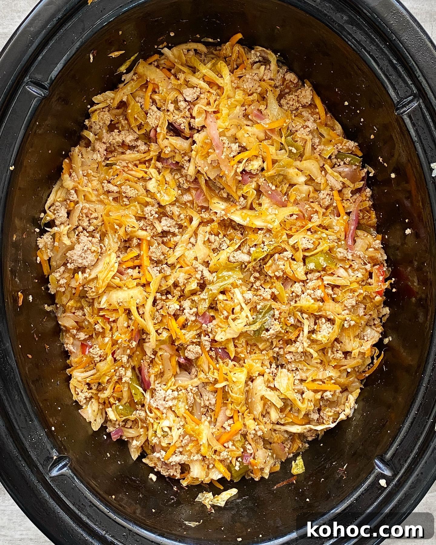 Spicy Slow-Cooker Turkey Slaw Recipe for Quick Weeknight Meals 5 overhead shot of cooked spicy turkey slaw in a black slow cooker