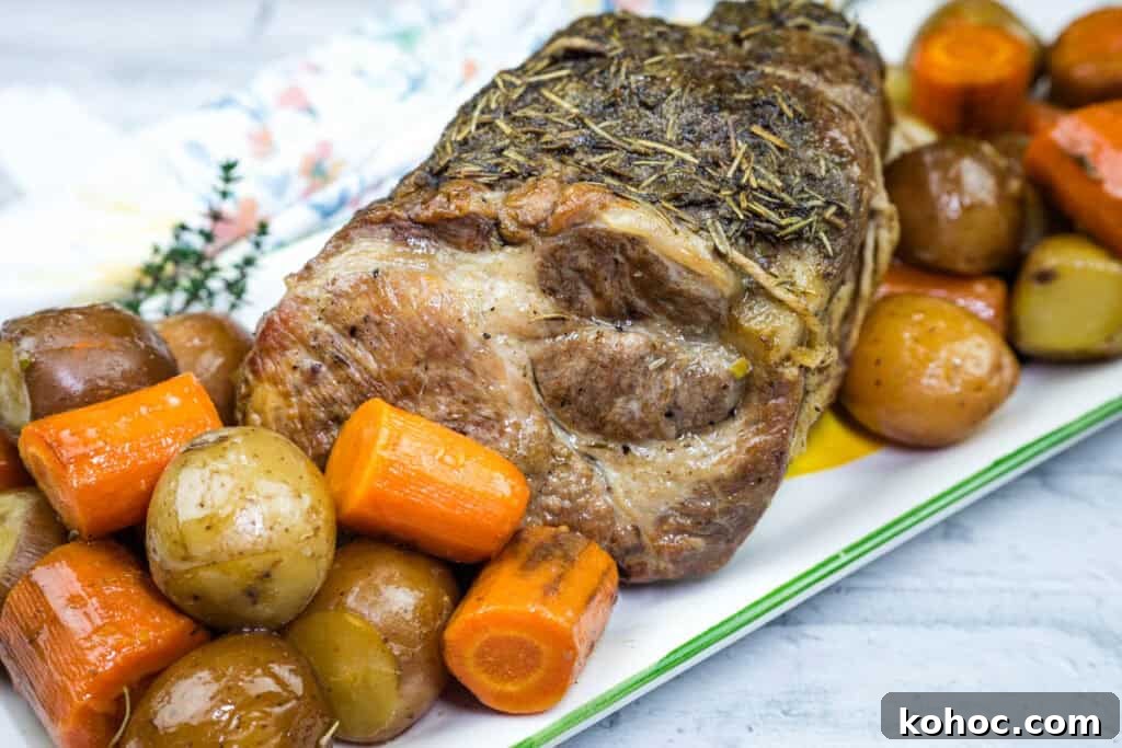 23 Dump-and-Go Slow Cooker Recipes That Taste Homemade 2 A plate with a Slow Cooker Herb-Crusted Pork Roast and roasted vegetables.