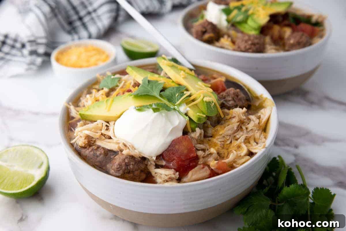23 Dump-and-Go Slow Cooker Recipes That Taste Homemade 15 Two bowls of Slow-Cooker Taco Soup next to sliced lime.