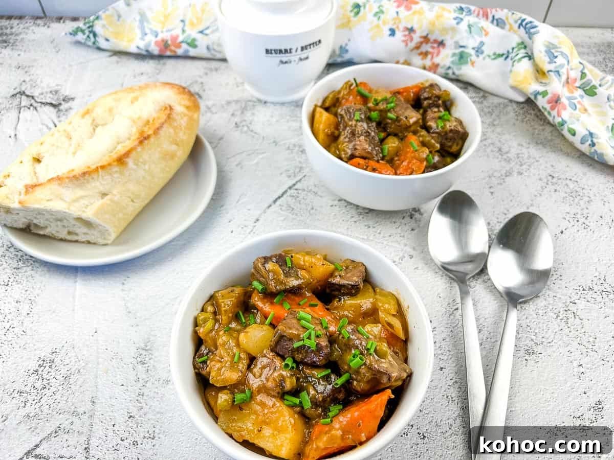 23 Dump-and-Go Slow Cooker Recipes That Taste Homemade 18 Beef stew in a white bowl with carrots and potatoes.