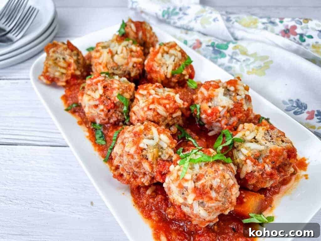 23 Dump-and-Go Slow Cooker Recipes That Taste Homemade 5 A white rectangular plate with slow cooker porcupine meatballs, garnished with fresh herbs.