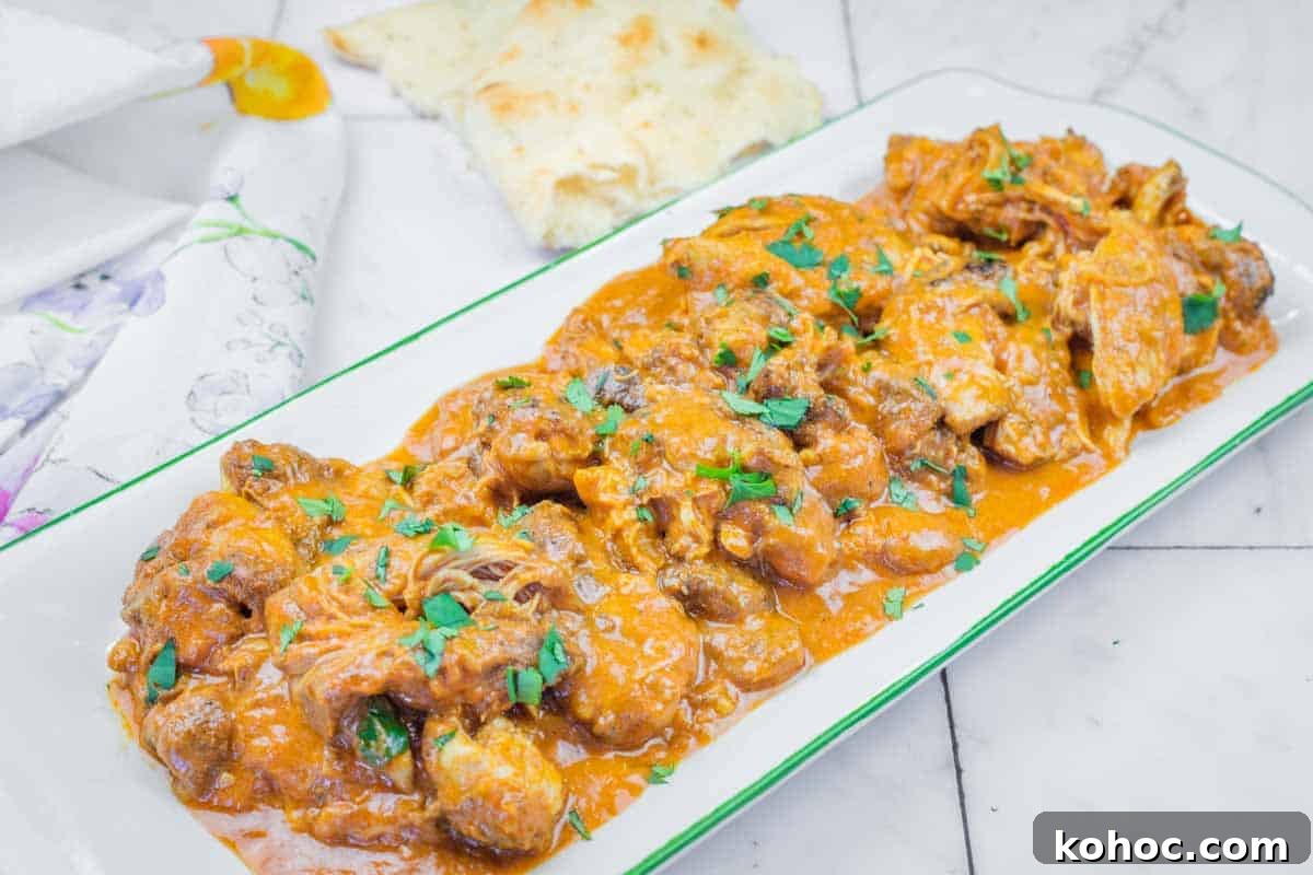 23 Dump-and-Go Slow Cooker Recipes That Taste Homemade 6 A rectangular plate of Chicken Tikka Masala with herbs on top.