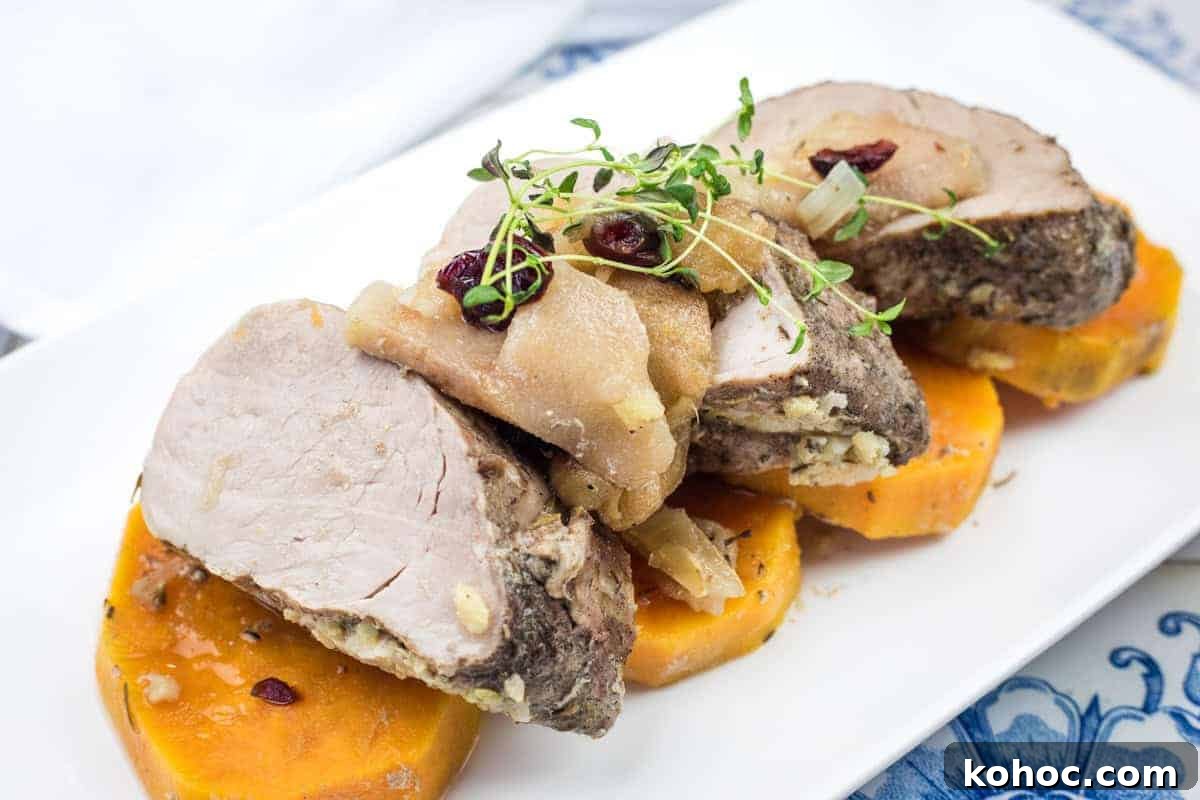 23 Dump-and-Go Slow Cooker Recipes That Taste Homemade 10 Sliced slow cooker pork roast with sweet potatoes & apples on a white plate.