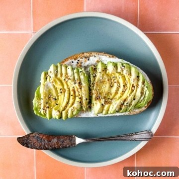 Creamy Avocado Lime Tartine Recipe for Fresh Breakfast 12 an avocado tartine sits on a blue plate with a vintage silver knife over a peach tile background.