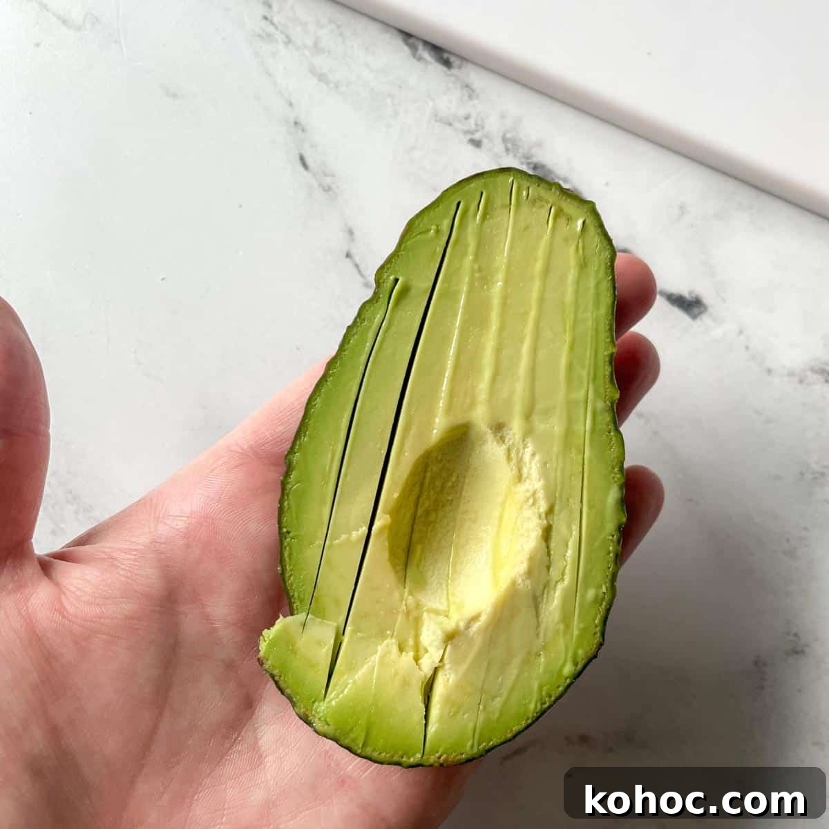 Creamy Avocado Lime Tartine Recipe for Fresh Breakfast 7 Half of an avocado is shown thinly sliced in its skin.