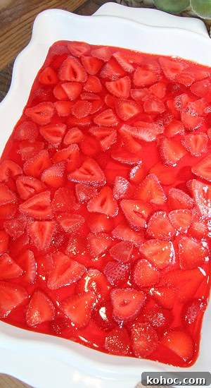 Strawberry Pretzel Dessert, made in a 13 x 9" dish, is perfect for sharing. Fresh strawberries floating in a gelatin over a cream cheese layer and buttery pretzel crust.