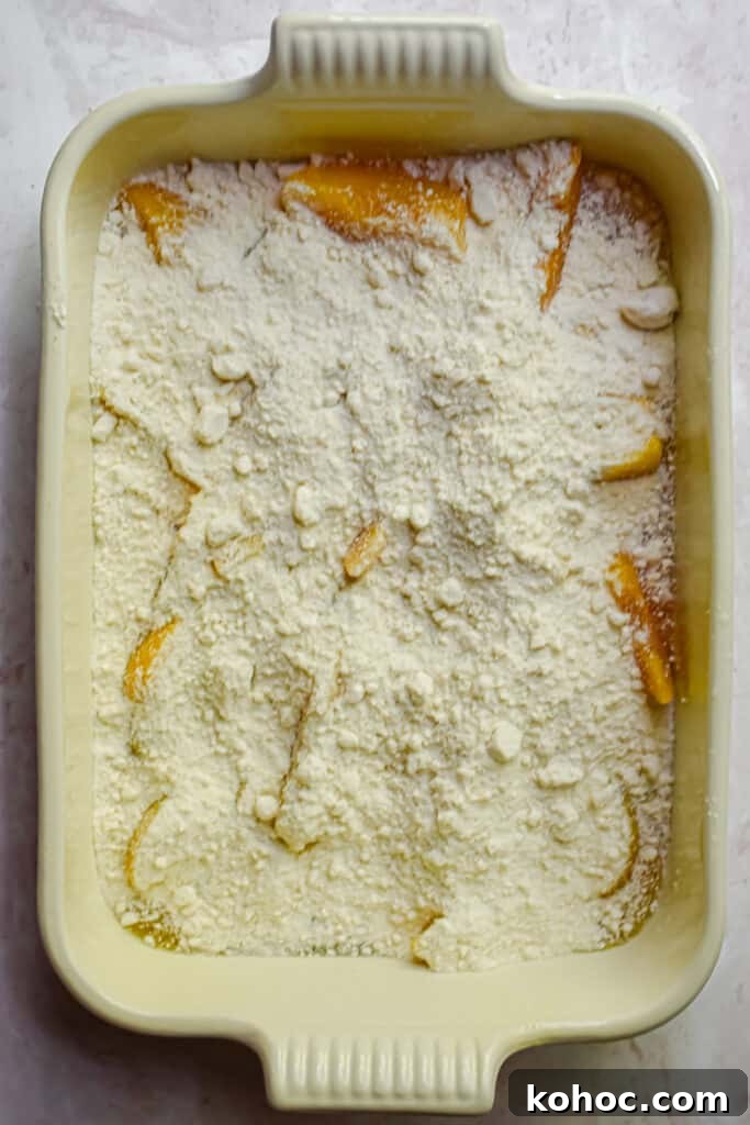 The cake mix is poured over the peaches.