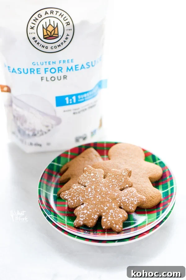 Gluten-Free Gingerbread Cookies Recipe for Perfect Holiday Bakes 9 Gluten Free Gingerbread Cookies on a red and green plaid plate with a bag of King Arthur Gluten Free Measure for Measure Flour in the background