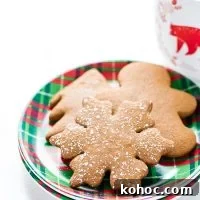 gluten free gingerbread cookies on a green and red plaid plate with a mug of milk in the background
