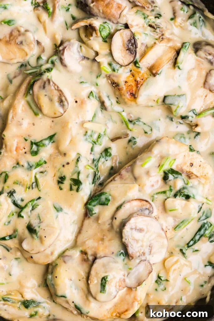 Creamy Garlic Pork Chops with Lighter Sauce 11 A close up shot of creamy garlic pork chops with spinach and mushrooms.
