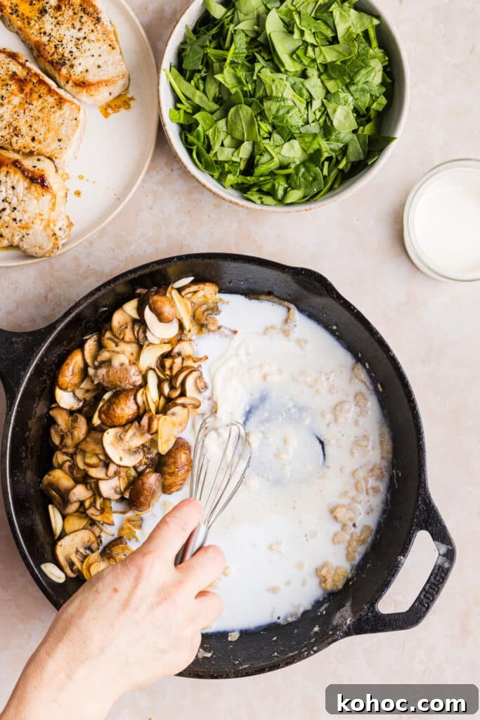 Creamy Garlic Pork Chops with Lighter Sauce 7 Milk being added to a pan with mushrooms to make a creamy sauce.