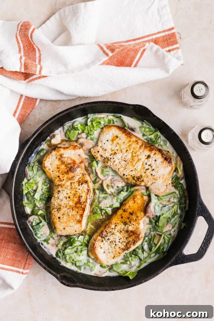 Creamy Garlic Pork Chops with Lighter Sauce 9 Pork chops being added back to a pan with veggies and a creamy garlic sauce.