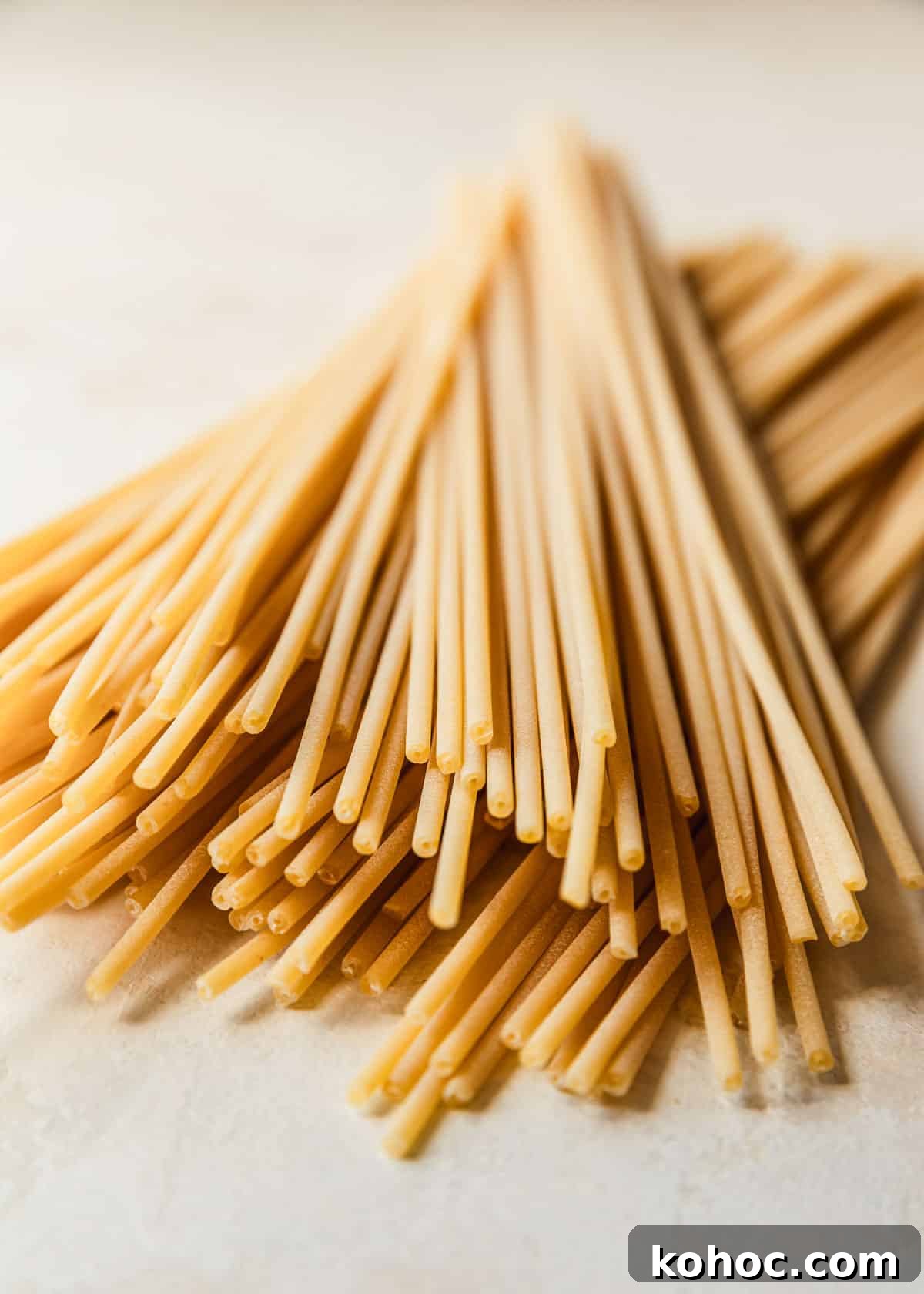 Crispy Shallot Bucatini Cacio e Pepe Recipe 4 Pasta on a tan counter.