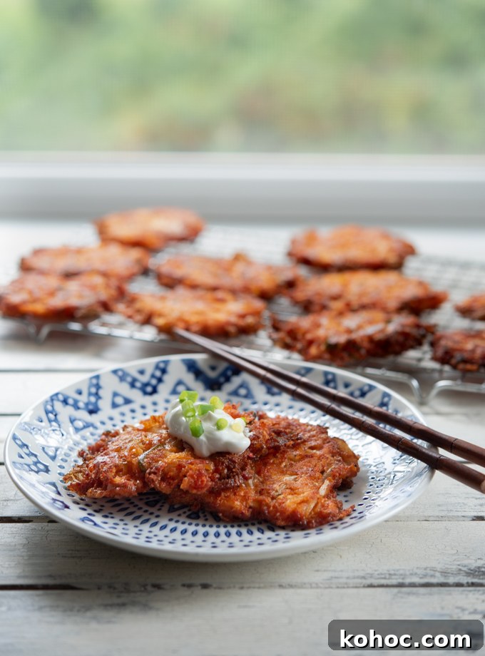 Cheesy Kimchi Potato Pancakes Recipe for Crispy, Flavorful Korean-Style Pancakes 2 Cheesy Kimchi Potato Pancakes are garnished with a dollop of sour cream.