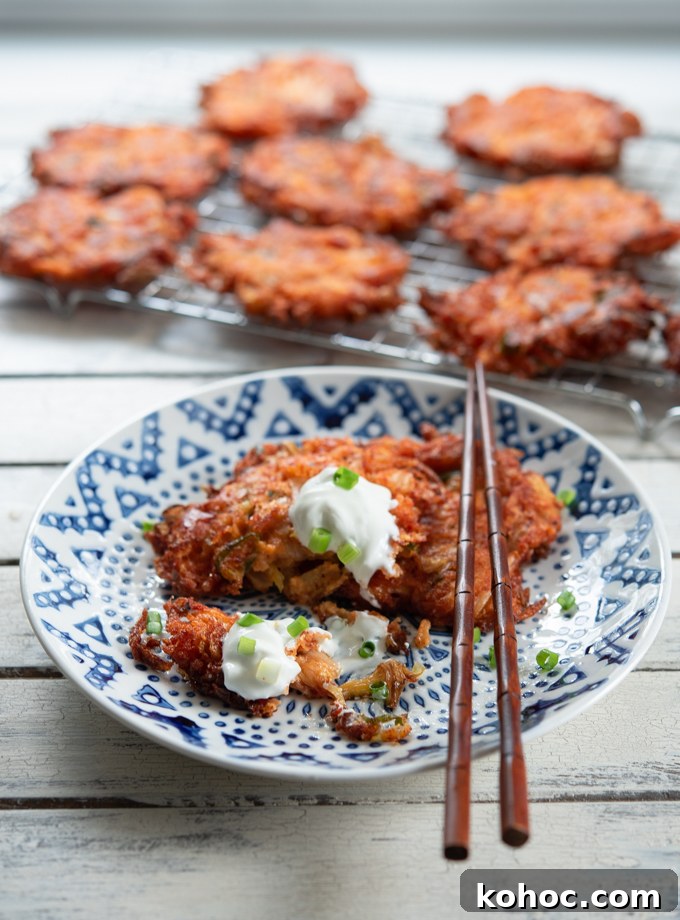 Cheesy Kimchi Potato Pancakes Recipe for Crispy, Flavorful Korean-Style Pancakes 12 Cheesy Kimchi Potato Pancakes served with sou cream on a plate.
