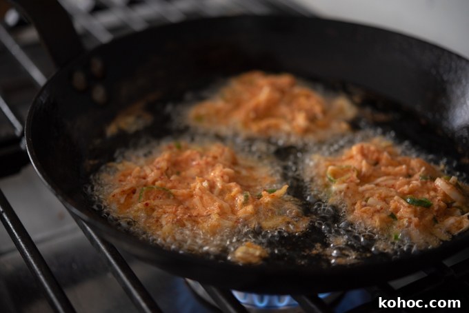 Cheesy Kimchi Potato Pancakes Recipe for Crispy, Flavorful Korean-Style Pancakes 9 Kimchi Cheese Potato pancakes frying in oil.
