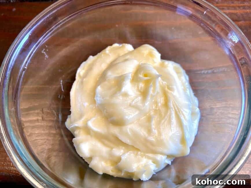 Soft Homemade Cinnamon Rolls with Cream Cheese Glaze 14 Mixed icing in a glass bowl.