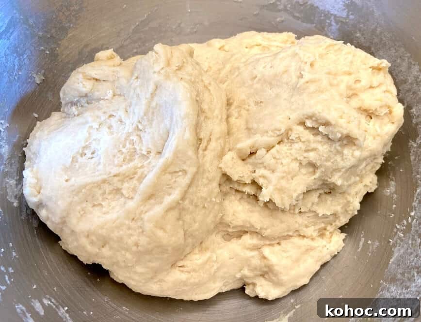 Soft Homemade Cinnamon Rolls with Cream Cheese Glaze 7 Dough forming together in a bowl.