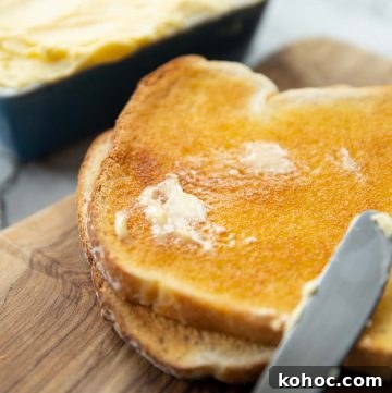 smudge of butter melting into slice of toast on chopping board