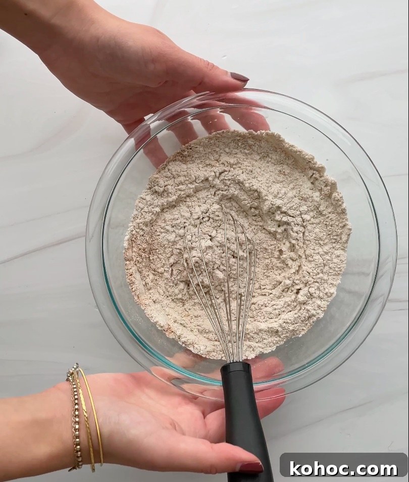 Crispy Gluten-Free Gingersnap Cookies You’ll Love 5 Dry ingredients with a whisk in a glass bowl.