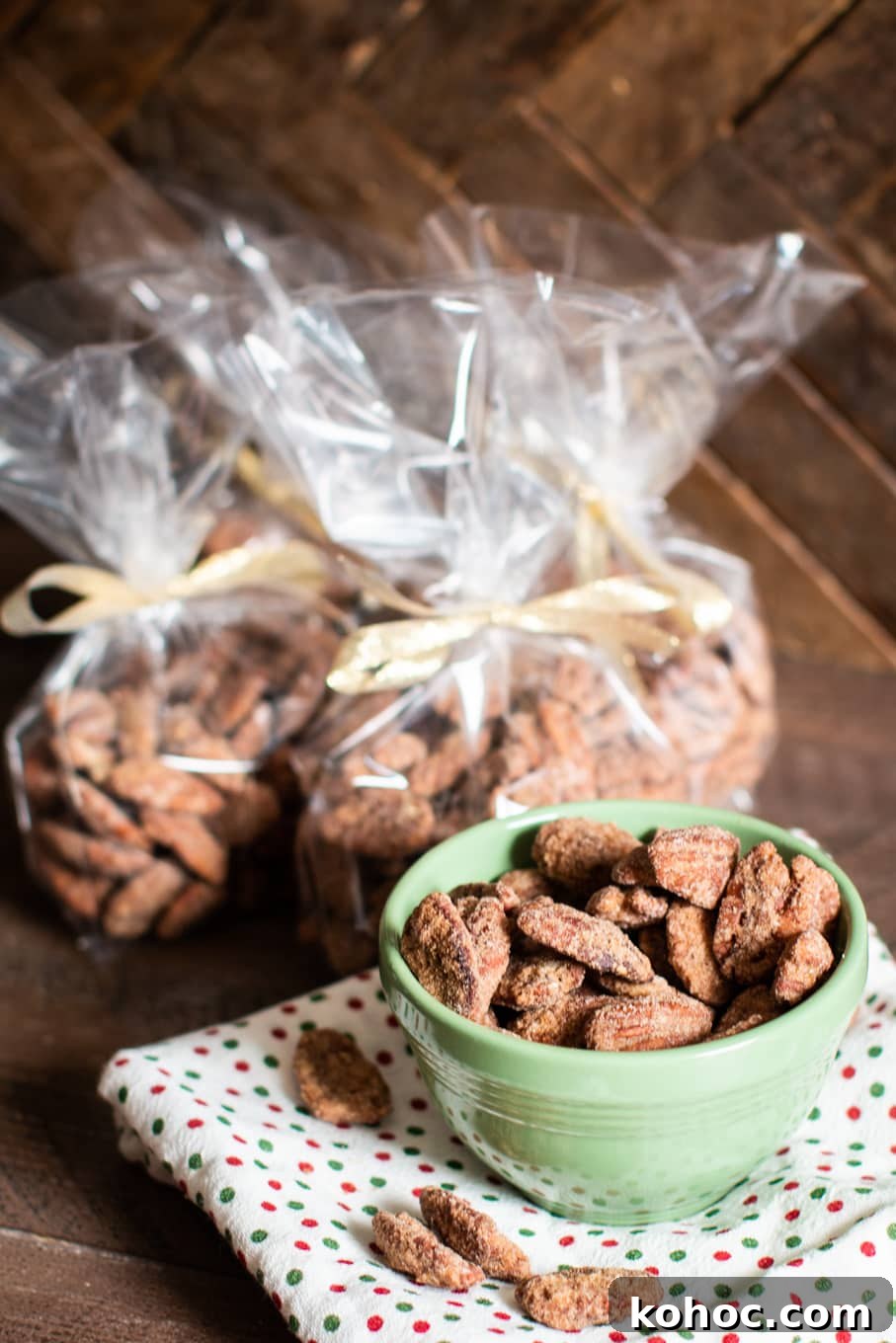 Perfectly Candied Pecans in the Slow Cooker (Simple Recipe) 8 pecans in green bowl with more pecans in decorative bags in the background.