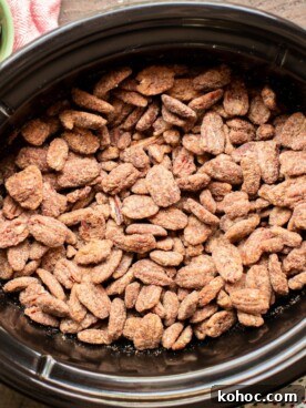 Perfectly Candied Pecans in the Slow Cooker (Simple Recipe) 9 full slow cooker of cooked candied pecans with polka dot napkin on the side.