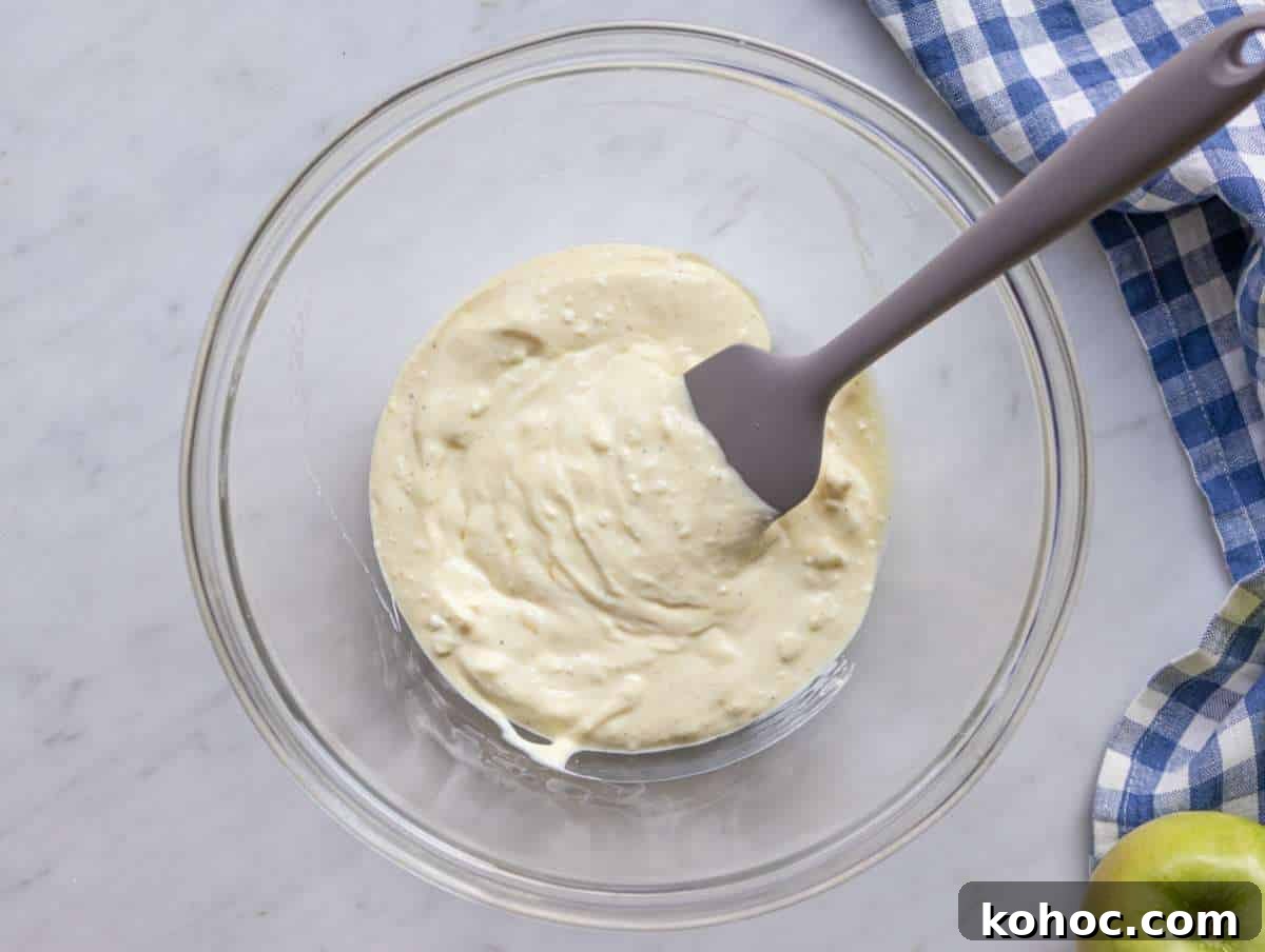 Waldorf Salad with Greek Yogurt Dressing — Light Apple & Walnut Salad 5 Step 1 Mixing creamy yogurt dressing for healthy Waldorf salad in a large bowl.