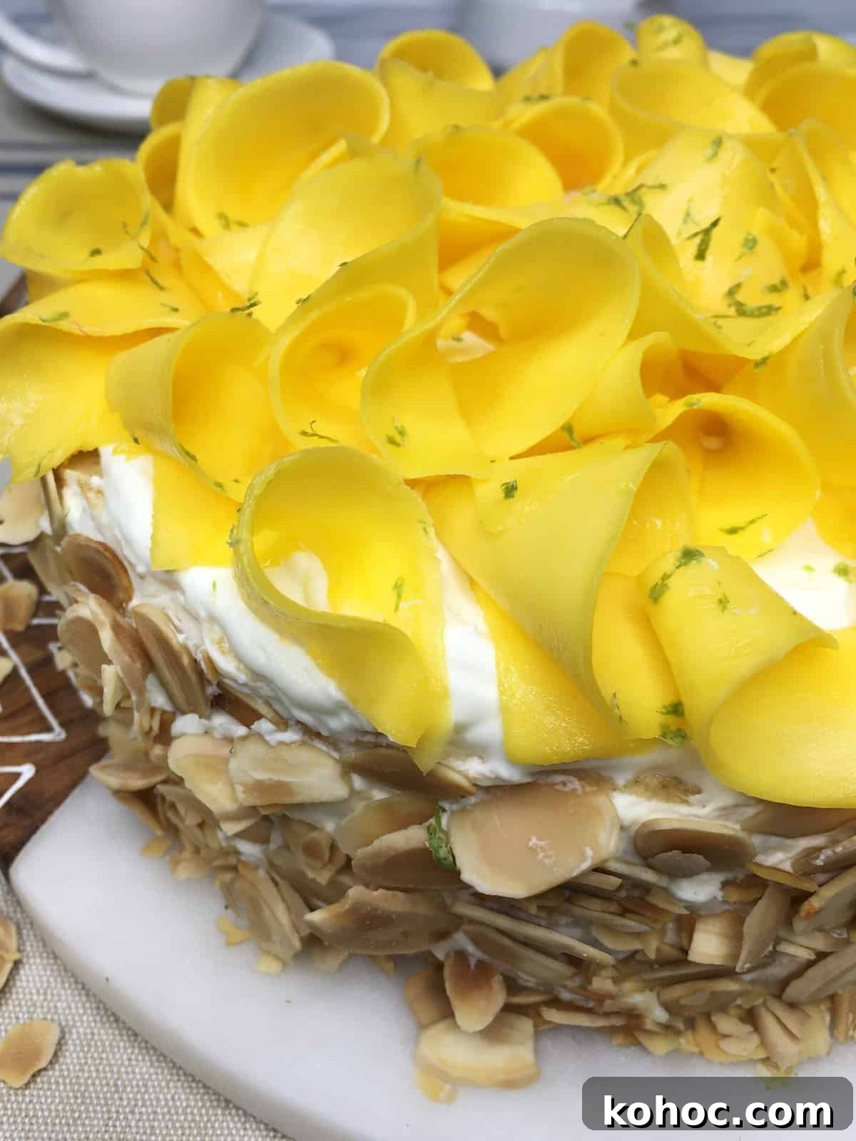 Mango Crepe Cake Recipe: Step-by-Step Guide for Silky Layers 3 Decorated mango layer cake on a marble board with dishes in the background