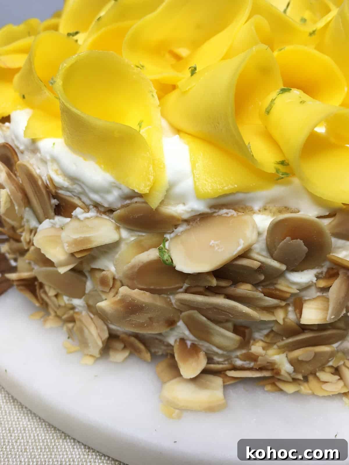 Mango Crepe Cake Recipe: Step-by-Step Guide for Silky Layers 5 Cake decorated with mango curls, lemon zest and sprinkled with toasted flaked almonds