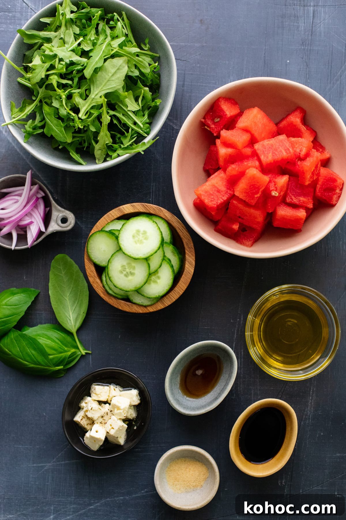 Watermelon, Feta & Basil Salad with Balsamic Glaze 3 ingredients for watermelon salad arranged on dark gray background.