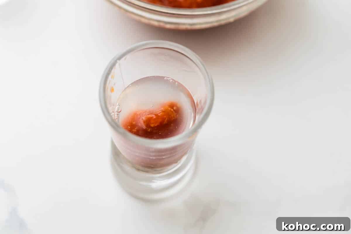 Topping the oyster shooter with vodka.