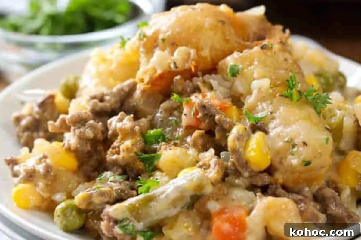 29 Tasty Meals You Can Make with Frozen Vegetables 12 A plate of shepherd's pie topped with melted cheese, featuring layers of ground meat with frozen peas, carrots, and corn, garnished with parsley.