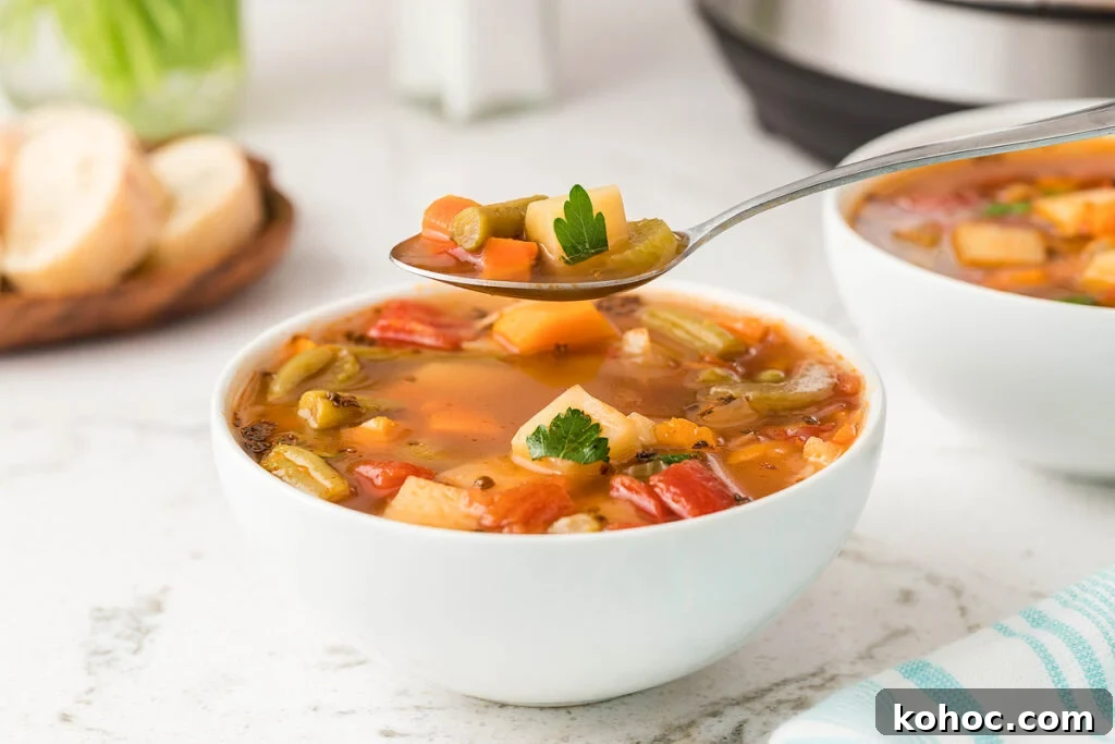 29 Tasty Meals You Can Make with Frozen Vegetables 3 A spoon taking a scoop of vegetable soup out of a white bowl.