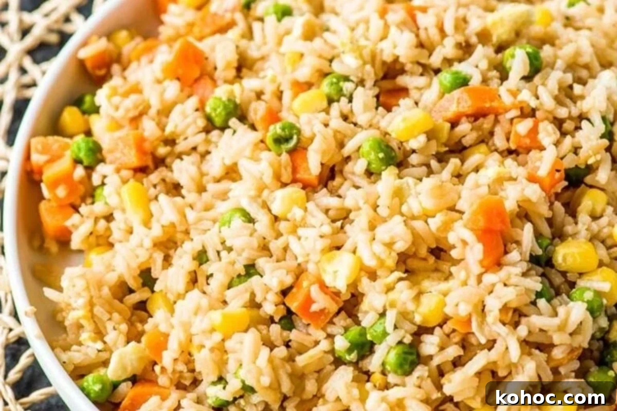 29 Tasty Meals You Can Make with Frozen Vegetables 10 Fried rice with frozen mixed vegetables in a white bowl.
