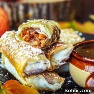 Crispy Apple Pie Spring Rolls with Filo Pastry 11 Stacked apple pie filo rolls with the top one being split in half to reveal the filling.