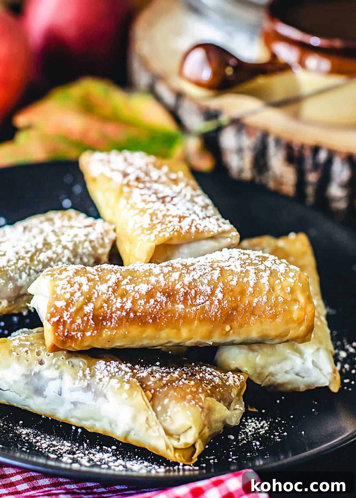 Crispy Apple Pie Spring Rolls with Filo Pastry 5 Golden fillo rolls filled with apple pie filling stacked on a plate.