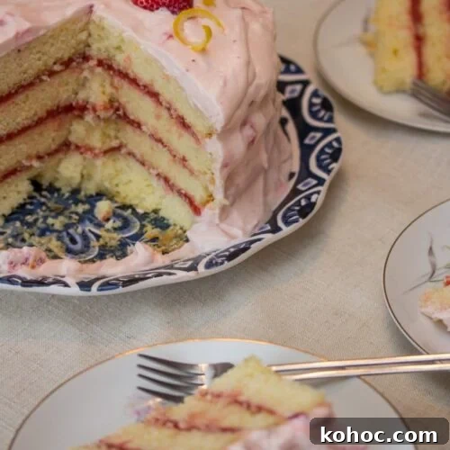 Strawberry lemonade layer cake with slices served on plates.