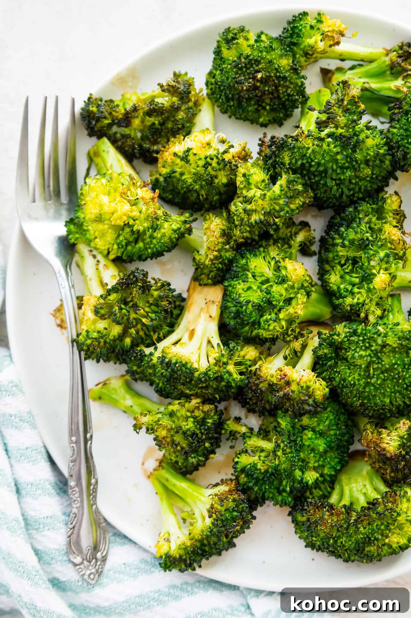 Crispy Air Fryer Broccoli Recipe in 15 Minutes 2 A plate of cooked broccoli with a fork beside the broccoli