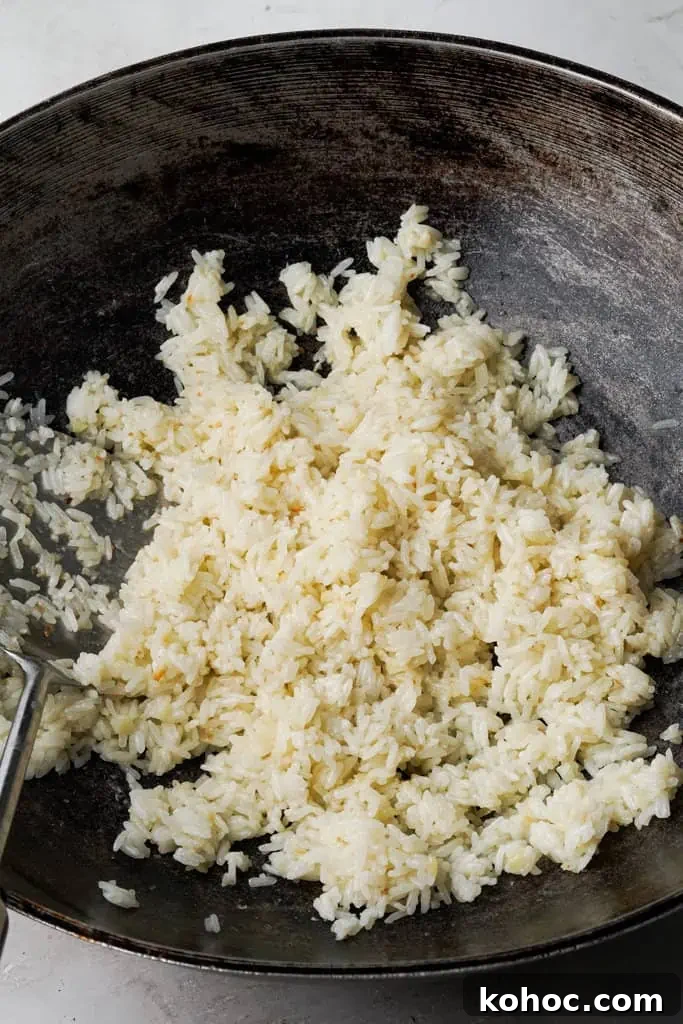frying rice in skillet for Filipino garlic rice