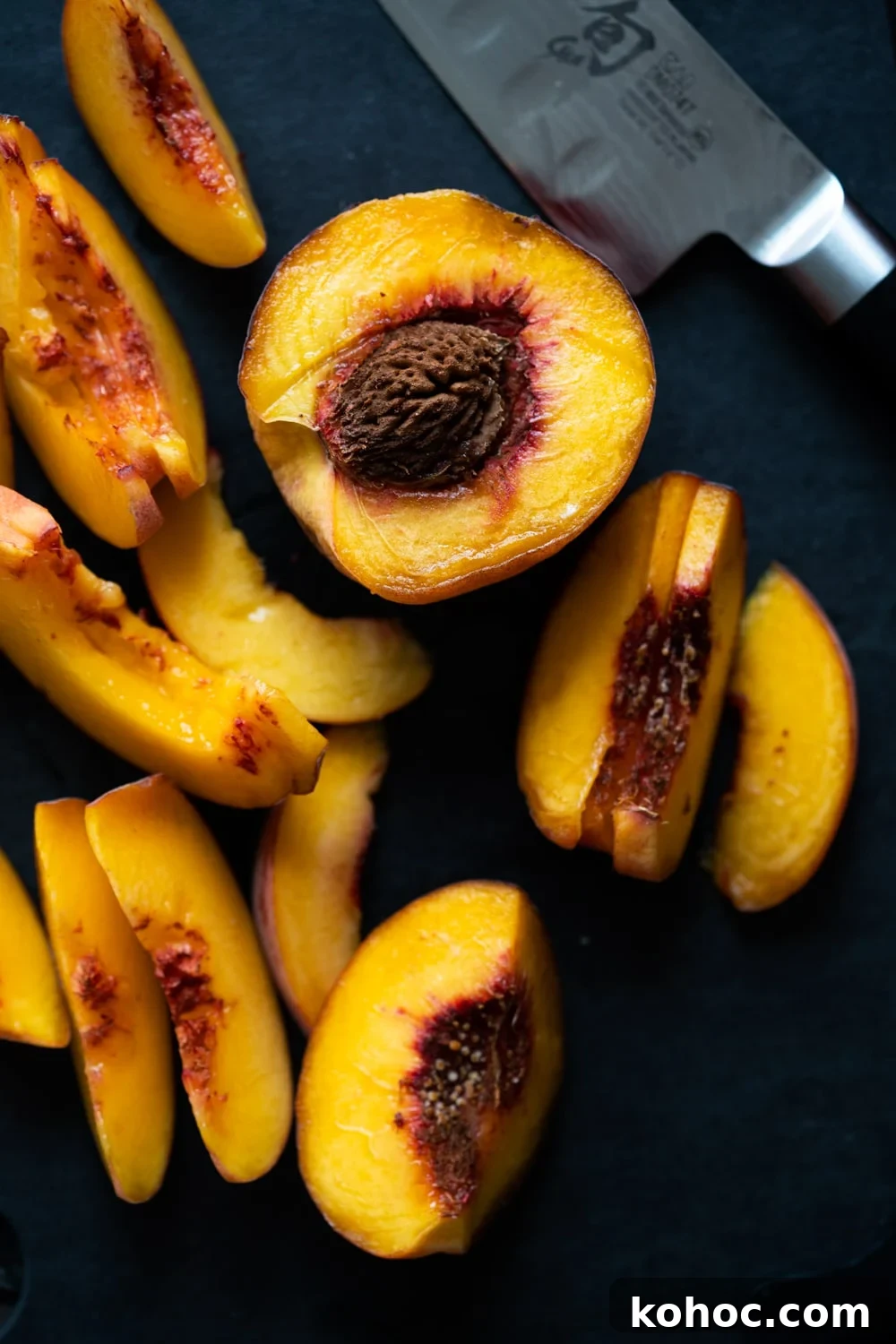 Keto Almond Flour Peach and Blackberry Crisp Recipe 3 Slicing peaches on a black cutting board
