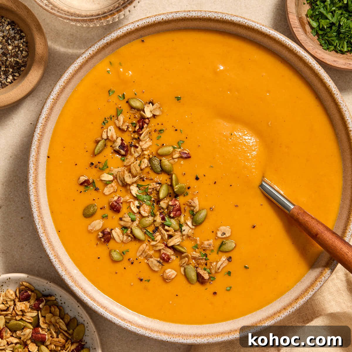 Roasted Red Pepper & Butternut Squash Soup — Dairy-Free Vegan Recipe 11 A bowl of roasted red pepper and butternut squash soup with toppings on the side.