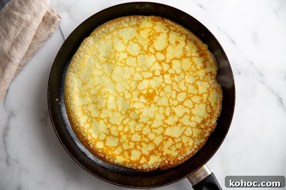 A cooked crepe in a non-stick skillet. 