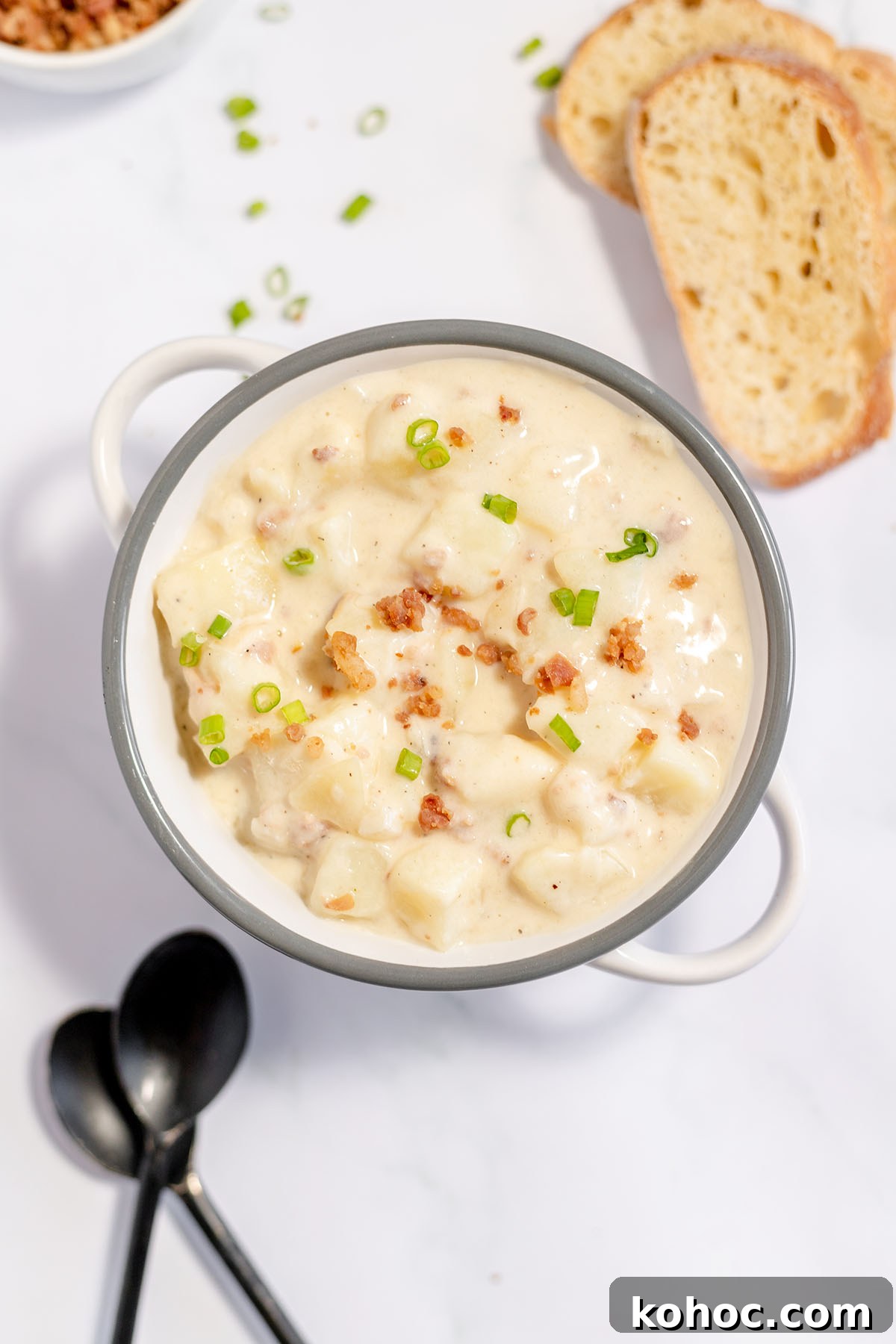 Creamy Baked Potato Soup with Crispy Bacon Topping 2 Baked Potato Soup in stockpot topped with bacon and green onions.