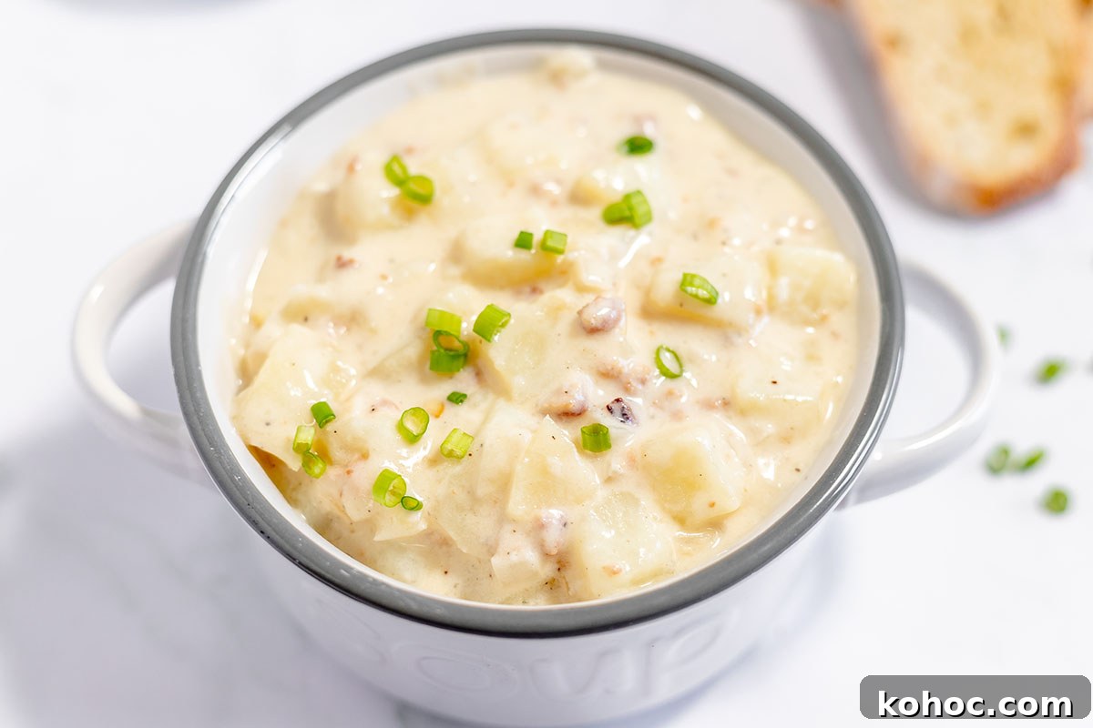 Creamy Baked Potato Soup with Crispy Bacon Topping 9 Baked potato soup is served in a soup bowl with handles.