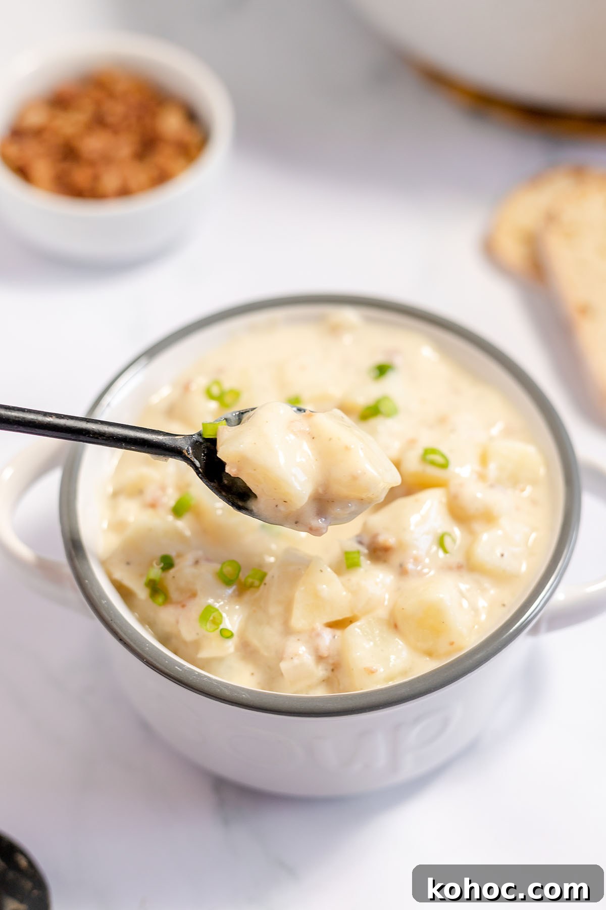 Creamy Baked Potato Soup with Crispy Bacon Topping 10 Spoonful of Baked Potato Soup over bowl.