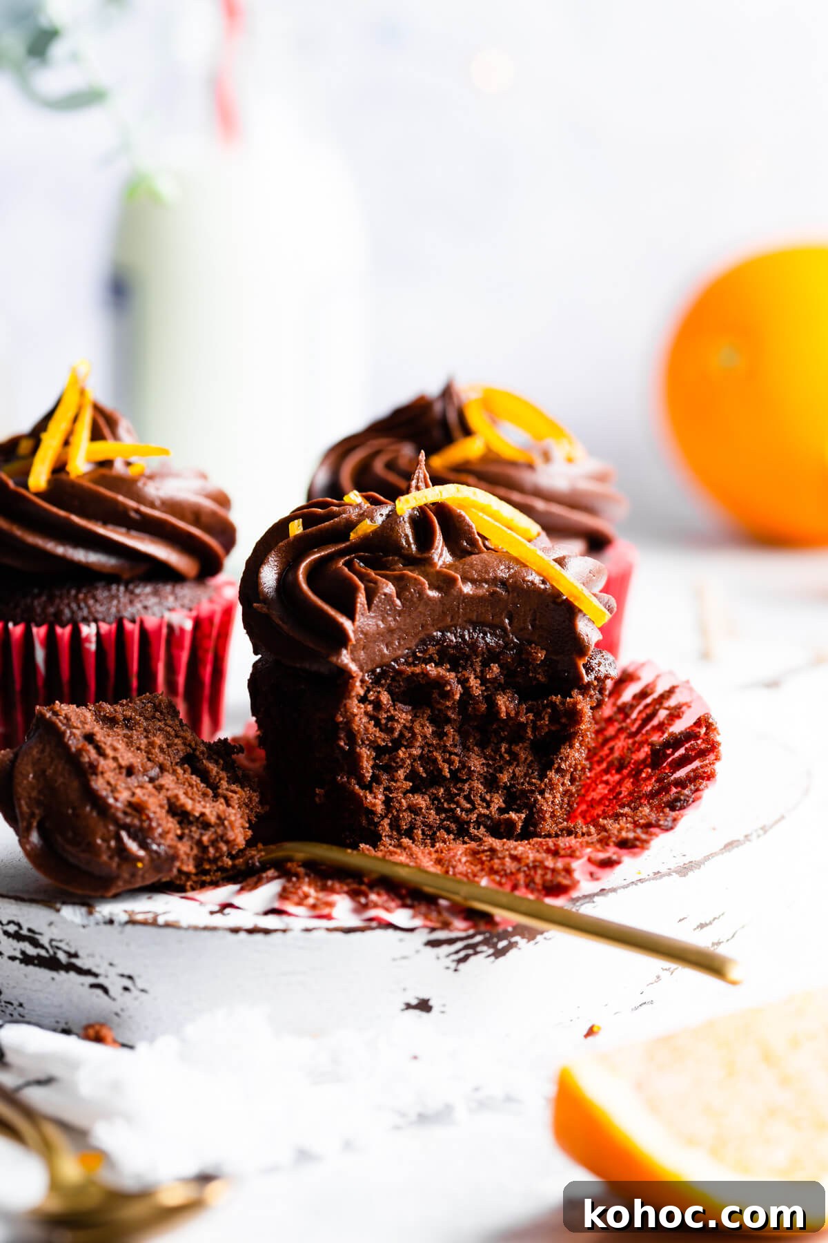 Chocolate Orange Cupcakes Recipe with Zesty Ganache 2 side view close up at a chocolate cupcake with a spoonful of it missing