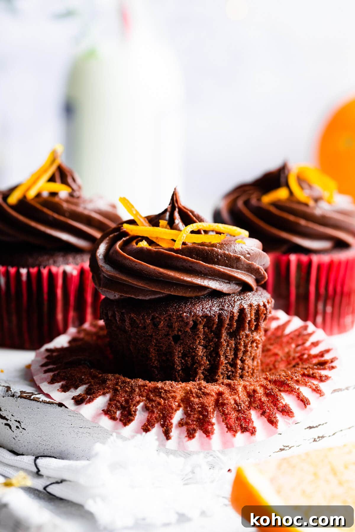 Chocolate Orange Cupcakes Recipe with Zesty Ganache 10 side super close up at a chocolate orange cupcake with paper case peeled off