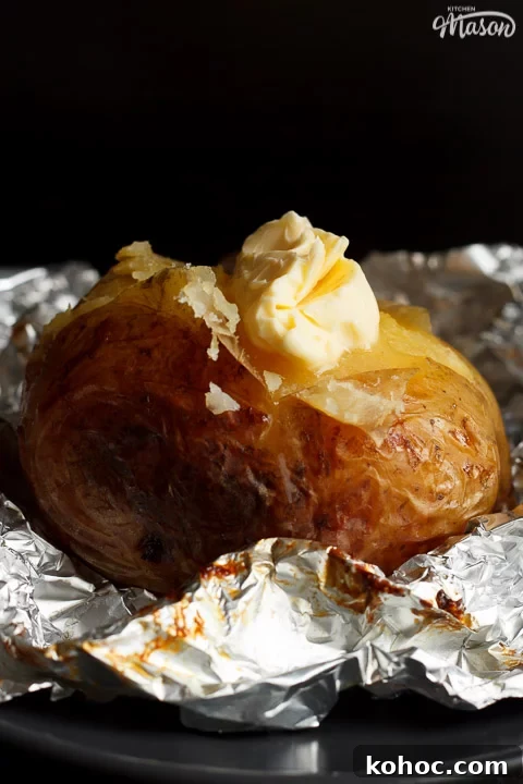 Slow Cooker Baked Jacket Potatoes Recipe 6 A slow cooker jacket potato on foil topped with melting vegan butter