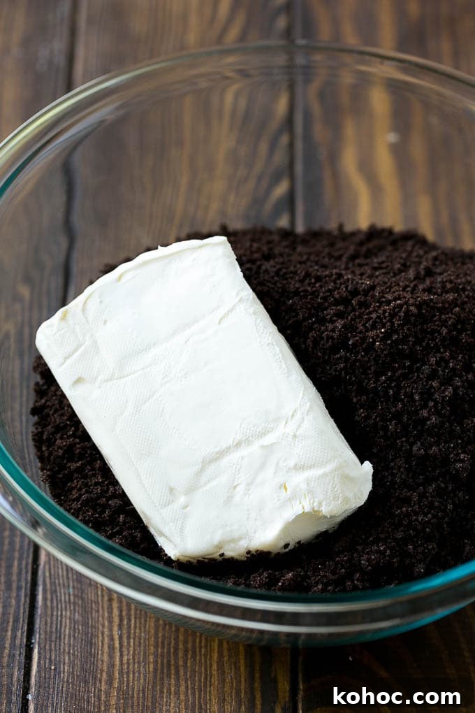 Oreo balls ingredients Cookie crumbs and cream cheese in a bowl.